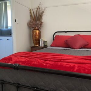 Bottlebrush Apartment bed w ensuite entry and red throw